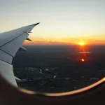 Sunset over a city seen through an airplane window