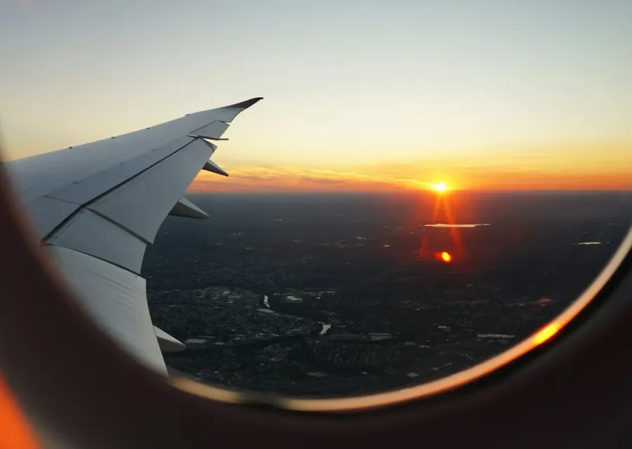 Sunset over a city seen through an airplane window