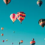 Hot air balloons drifting across a clear blue sky