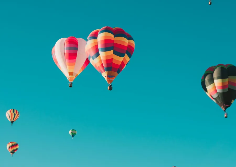 Hot air balloons drifting across a clear blue sky
