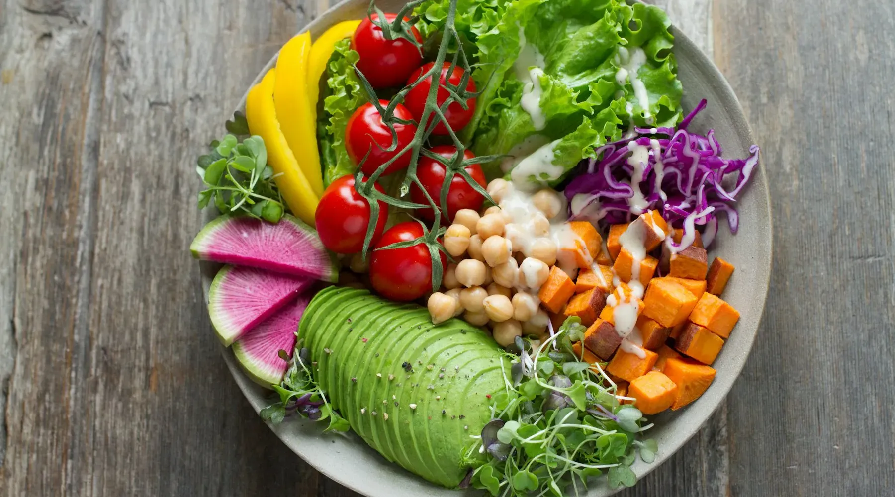 Bowl of avocado, chickpeas, tomatoes and greens