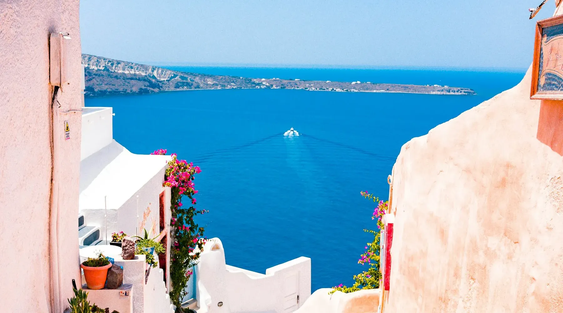 Whitewashed stairway leading down to the blue Aegean in Santorini