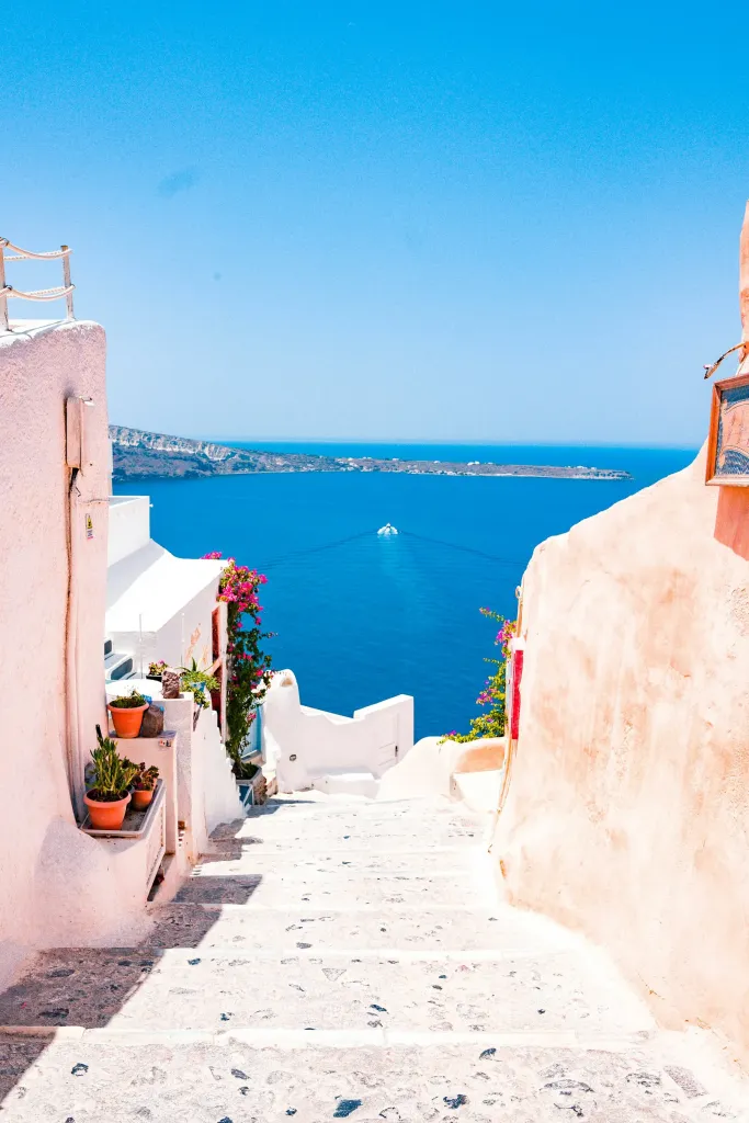 Whitewashed stairway leading down to the blue Aegean in Santorini