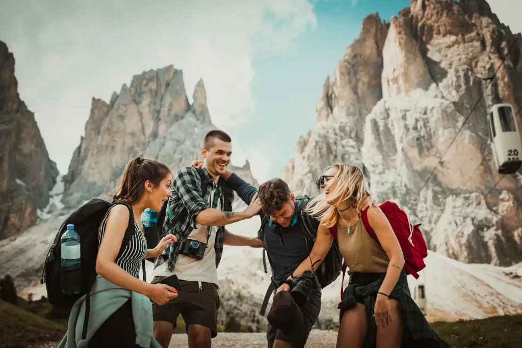 Friends with backpacks laughing among rocky peaks