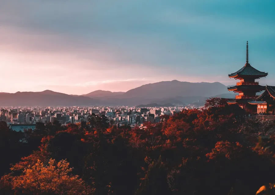 Kyoto pagoda above autumn trees at sunset